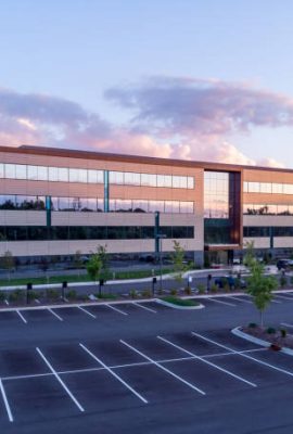 Evening shot of office building exterior with large parking lot